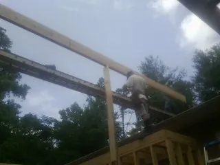 Carpenter setting a ridge beam over a new addition frame — Ice Dam Removal by Roofing Brothers in East Taunton