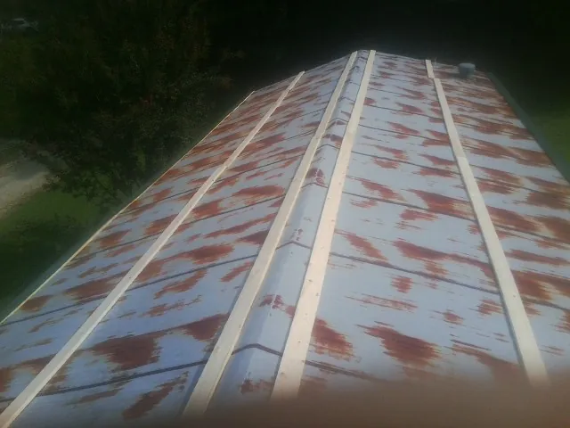 Rusted metal roof panels with new wood purlins before replacement — Storm Damage Roof Repair in East Taunton by Roofing Brothers