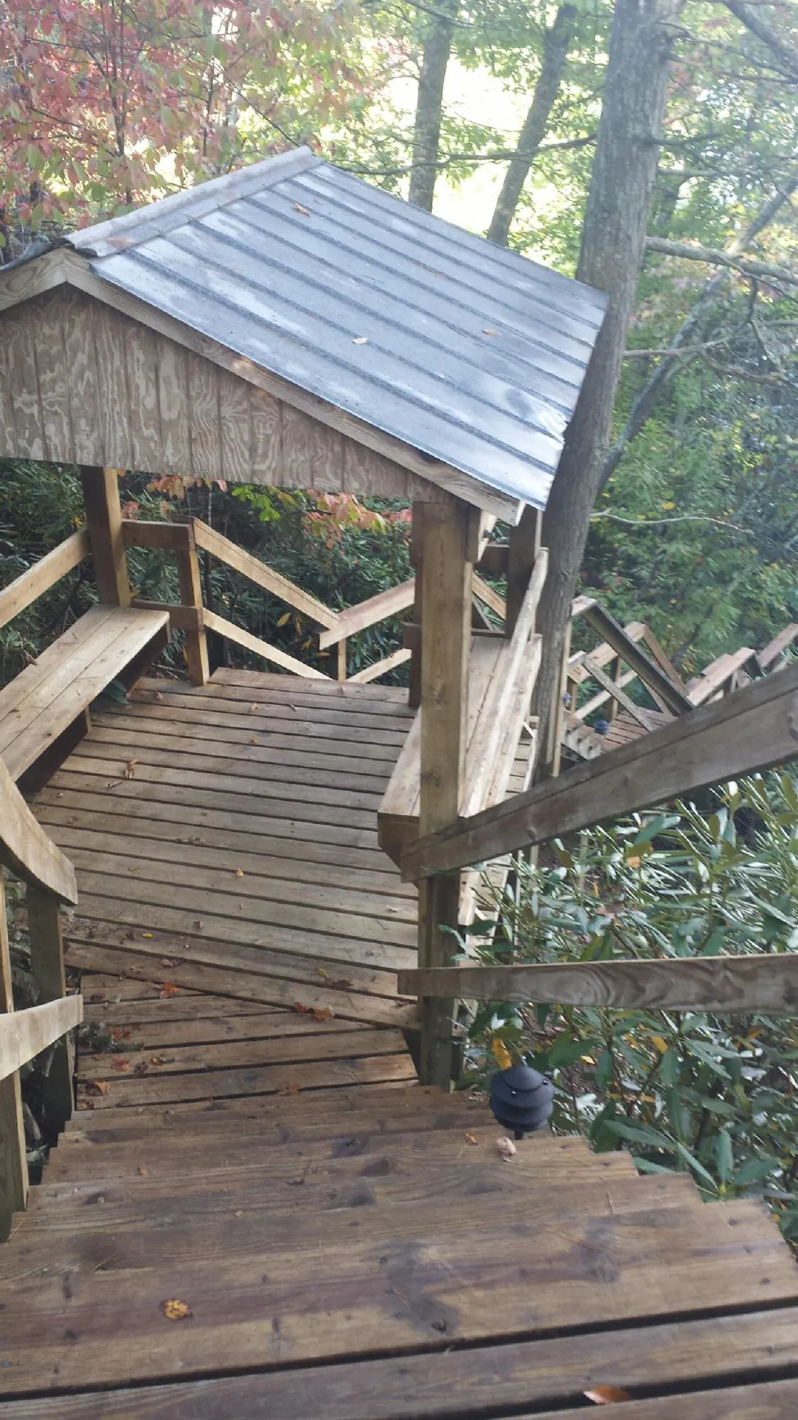 Metal roofed shelter over wooden steps on a wooded walkway — Skylight Repair & Installation work by our crew in East Taunton