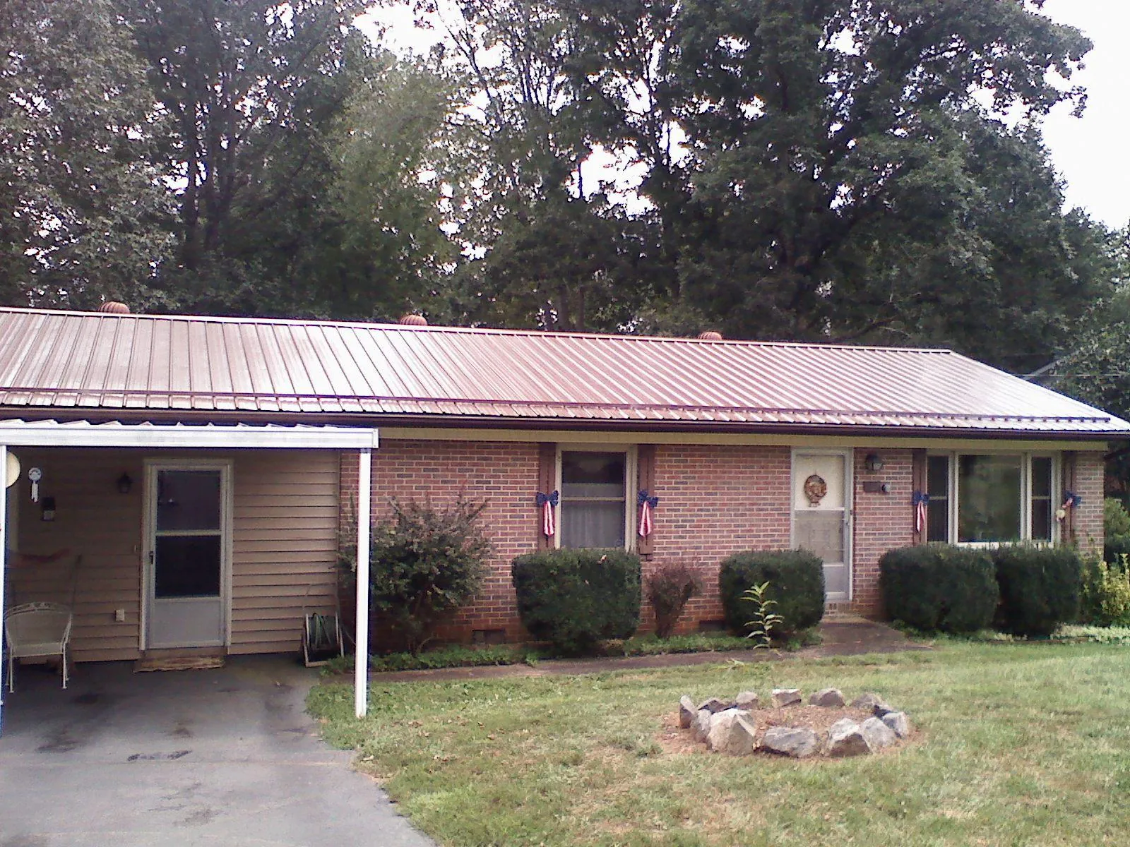 Bronze metal roof and carport on a brick ranch home — Roof Repair work by our crew in East Taunton